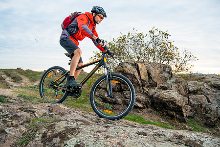 红色骑马山车的赛队员 在秋天落岩轨下 极端运动和Enduro自行车概念图片