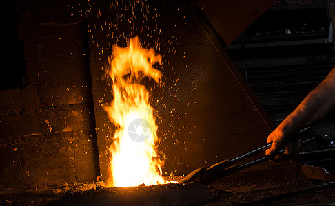 工作中的铁匠煤炭工艺锤子生产身体手臂铸造罢工职业齿轮图片