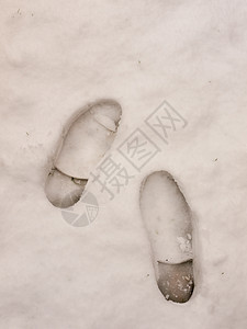 两块大脚印在雪地底背景上 紧紧贴近图片