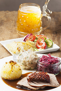 巴伐利亚烤猪肉和沙拉小腿火腿烹饪午餐肉汁饺子面包木头黄瓜图片