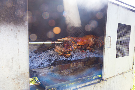 传统的巴肯菜  一整只猪在野火上烤焦了动物小猪煤炭拉刀烹饪食物美食烧烤餐厅木炭图片