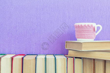 在紫花墙和茶杯上有很多不同的书图片