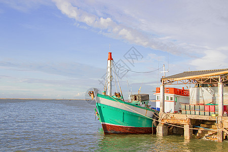 绿渔船在码头上用蓝色洗白白色的蓝帆船海岸反射假期天空渔业血管海洋港口绳索图片
