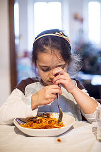 儿童在家厨房吃意大利面 在厨房里吃意面面条午餐食物饥饿女孩孩子童年孩子们营养食欲图片