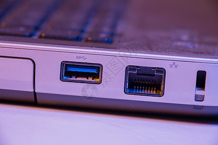 用笔记本电脑特写以太网电缆和USB端口图片