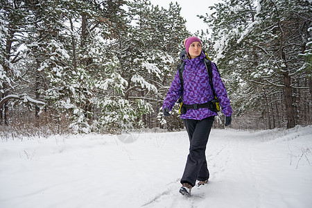 在美丽的冬季森林里 女人和大背包一起远足旅游天气天空女孩冒险活动季节假期运动成就图片