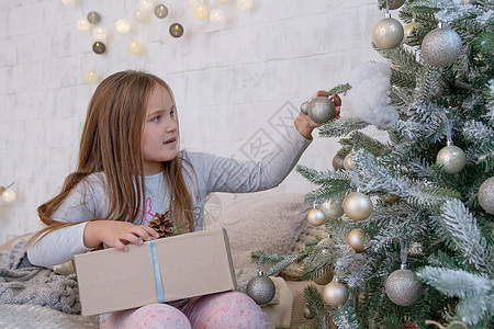 圣诞树下的女孩与球派对展示喜悦幸福家庭女儿礼物惊喜孩子玩具图片