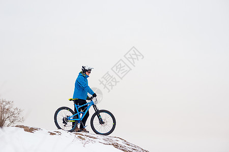 蓝骑山的赛车手在落基温冬山上被雪覆盖 极端运动和概念自行车车轮山地车天空行动爬坡踪迹速度头盔娱乐图片