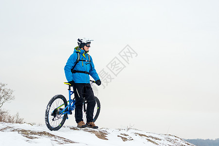 蓝色休息中的赛车手的肖像 在落基温冬山上用山堤打劫 极端运动和概念岩石男性速度山地车活动锻炼踪迹运动员骑士男人图片