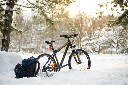 山上骑车 背包和盔甲 在美丽的冬季森林里 由太阳 冒险与旅行概念图片