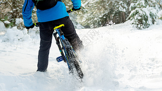 在美丽的冬季森林中的山上骑车的蓝色漂泊赛事中 极具体育和概念运动木头娱乐活动骑士头盔踪迹自行车锻炼男人图片