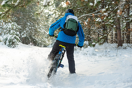 在美丽的冬季森林中的山上骑车的蓝色漂泊赛事中 极具体育和概念活动踪迹耐力赛自行车木头漂移运动车轮男性男人图片