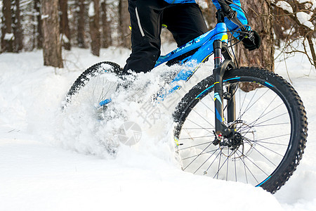 在美丽的冬季森林里 赛车手在山上骑摩托 极具运动力和概念图片