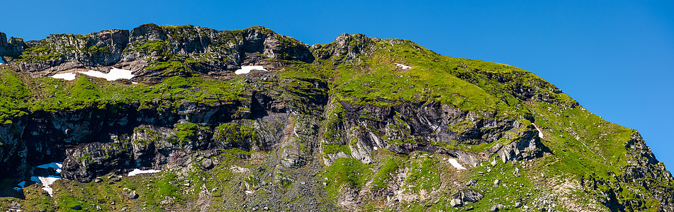 山脊 有岩石悬崖和草坡图片