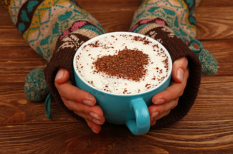 女人手握着全拿铁卡布奇诺咖啡杯泡沫桌子木板饮料牛奶巧克力手掌女士手套杯子图片