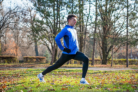 健康的生活方式和运动概念 年轻男性跑步者在寒冷的阳光秋天早晨公园展展男人赛跑者运动员活动叶子跑步慢跑者锻炼保健训练图片