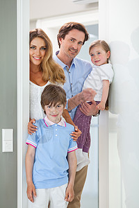 在门口的幸福家庭女儿住宅乐趣男生孩子们女性母亲父母爸爸财产图片