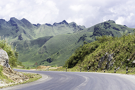 长宽的农村道路在老挝穿过绿色山丘小路环境曲线自由旅游运输晴天场景沥青全景图片