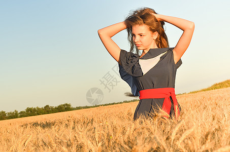 一位年轻女子站在田里的耳朵里图片