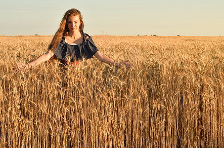 一位在田里站着的毛发无缝的年轻女子图片