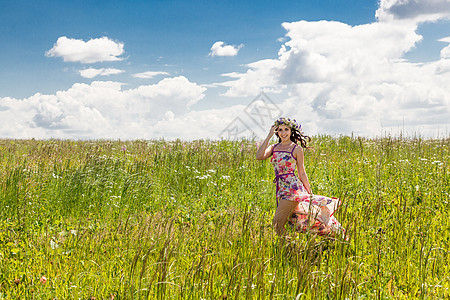 田间美丽的女孩自由女性女士裙子绿色天空农村太阳草地闲暇图片