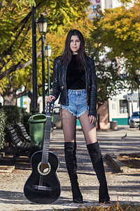 配有经典吉他女青年爱好牛仔裤细绳女士音乐家艺术家冒充黑色乐器花园图片