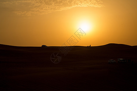 迪拜甜点中的日落护航勘探踪迹波纹乐趣金子大篷车沙丘冒险土地背景图片