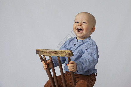 一个快乐的男孩坐在椅子上图片
