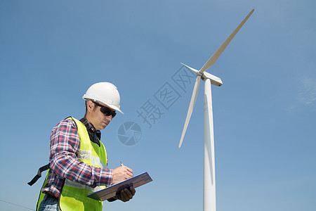 电动工程师在风力涡轮机剪贴板上撰写报告工人商业绿色创新涡轮写作发电厂男人风车生产图片
