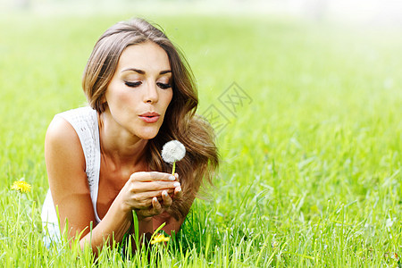 有着花朵的美丽年轻女子女孩裙子金发白色幸福女士微笑绿色成人公园图片