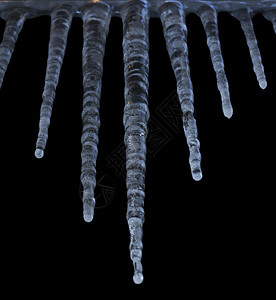 冰柱挂在地上  以结构化的方式与外界隔绝 黑色背景气候天气温度季节水晶季节性冻结图片
