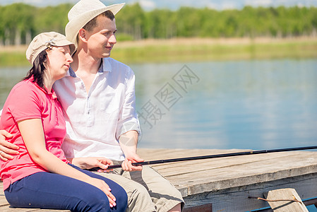 在码头赤脚快乐的一对情侣 骑着漂亮的船钓鱼图片