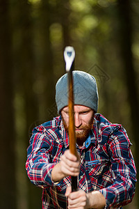 伐木工人在树林里用斧头砍木头图片
