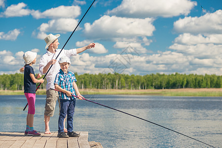 女孩和男孩与父亲学习钓鱼 周末钓鱼图片