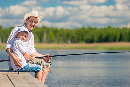 一边钓鱼一边在木头码头钓鱼的快乐男人图片
