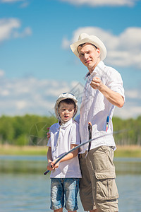 父亲和儿子在码头上钓着大鱼 在钩子上钓鱼图片