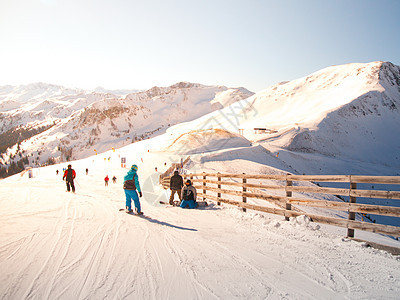 在阳光明媚的冬季日 在山地度假村滑雪坡上的人图片