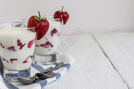 甜甜酸奶和草莓层 在蓝色条纹的玻璃杯中毛巾健康甜点玻璃牛奶美食浆果水果饮食桌子图片