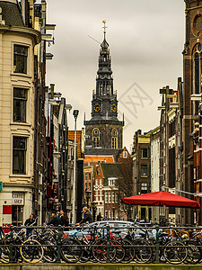 许多自行车停在阿姆斯特丹街上历史性运河建筑学路面生态旅行中心车轮纪念碑首都图片