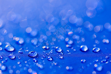 在蓝色防水布 backg 上特写水滴图案纺织品涂层织物天气水分气泡纤维水晶流动宏观图片