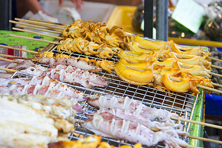 放在不锈钢筛子上的灰状鱿鱼午餐烹饪市场美味章鱼鱿鱼海鲜烧烤木炭食物图片