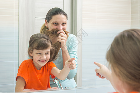 我女儿和妈妈在看我母亲的眼中玩得很开心 她像胡子一样把头发当脸朝她梳图片