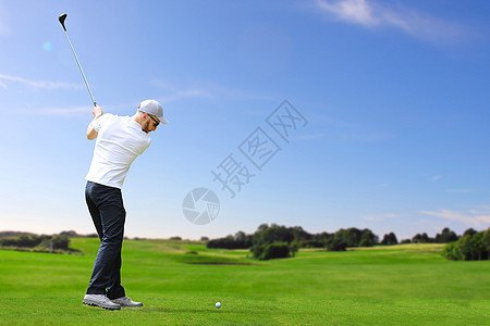 高尔夫球手击中高尔夫球游戏球座男人课程运动蓝色爱好俱乐部胡子天空图片