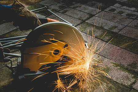 工厂的工业工人在砖头上切钢金属火花技术焊接制造业建造磨床劳动力量管道图片