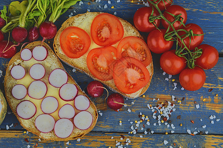 面包上涂有切片西红柿和萝卜的黄油 天然木本底新鲜零食 平板设计营养餐饮美食高架蔬菜小吃沙拉青菜早餐胡椒背景图片