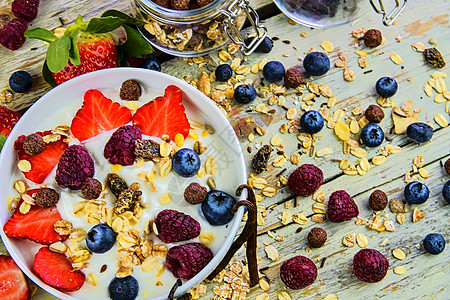 健康的早餐 麦片配酸奶 草莓 蓝莓 覆盆子和木制乡村背景的牛奶什锦早餐 概念 健身 饮食 健康和早餐蓝色小吃食物勺子燕麦营养覆盆图片