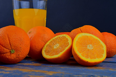 橘子 橙子 一杯橙汁和蓝木本底的手工柑橘饼 橙子切成两半材料吸管水果液体厨房果汁橙色铰刀早餐橘子汁背景图片