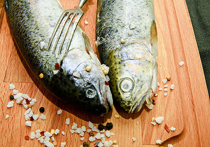 带香料和木板叉子的新鲜新生虹鳟鱼 健康食物和饮食概念图片