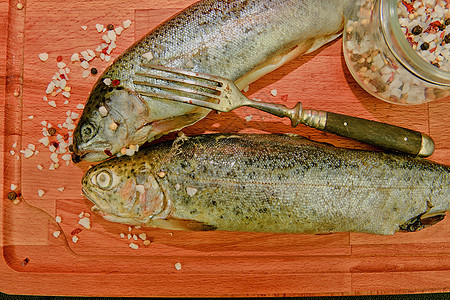 带香料和木板叉子的新鲜新生彩虹鳟鱼 健康食物和饮食概念 特写 添加软黑对比度图片