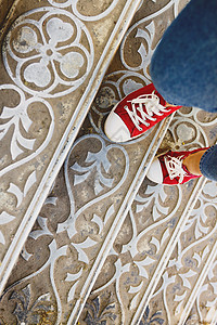 红色楼梯古色古香的金属楼梯上穿着牛仔裤和红色运动鞋的双腿 吨旅行青年街道界限途径城市地面鞋类女士男人背景
